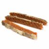 Primer plano de tres barritas de salmón con piel, snacks de salmón para perros naturales y crujientes.